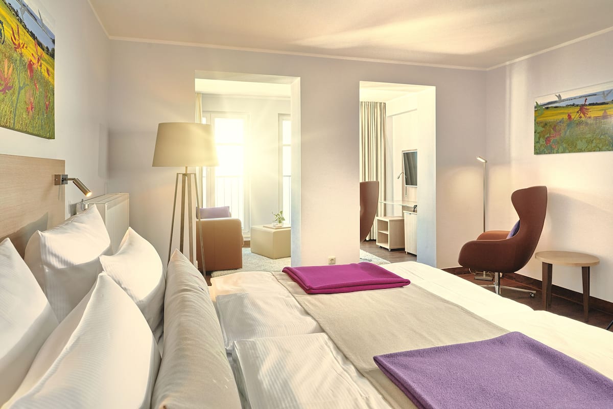 A hotel room with a bed, a chair, a desk, and a television.