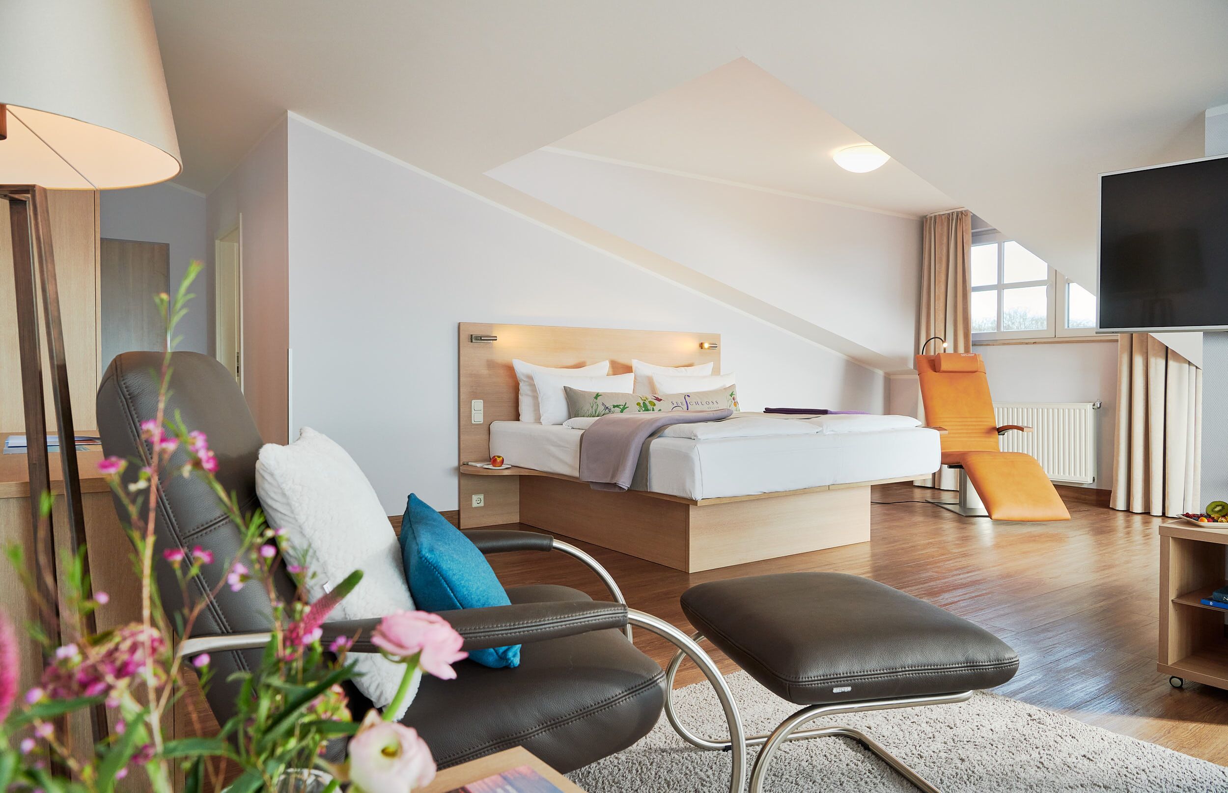 Une chambre d’hôtel moderne équipée d’un lit, d’un bureau, d’une chaise et d’un téléviseur.