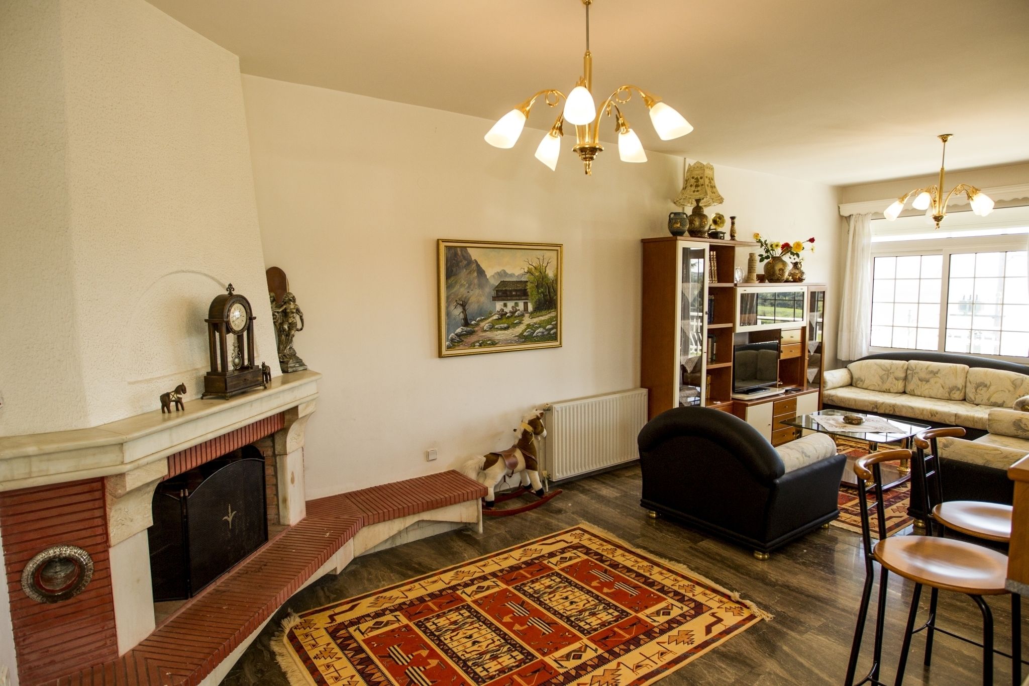 Una sala de estar con chimenea, un sofá, una mesa de centro y una estantería.