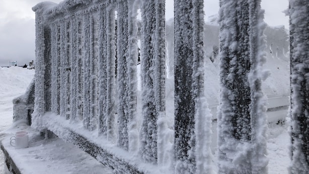 A snow-covered metal fence with icicles hanging from it. - Apartments Fichtelberger Blick (Oberwiesenthal)