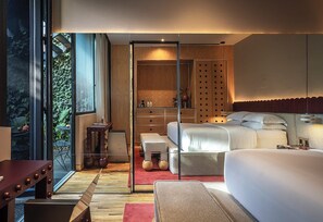 Ein modernes Schlafzimmer mit einem großen Bett, einem Holzschrank und einer Glastrennwand.