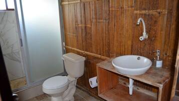 A bathroom with a toilet, a sink, and a shower.