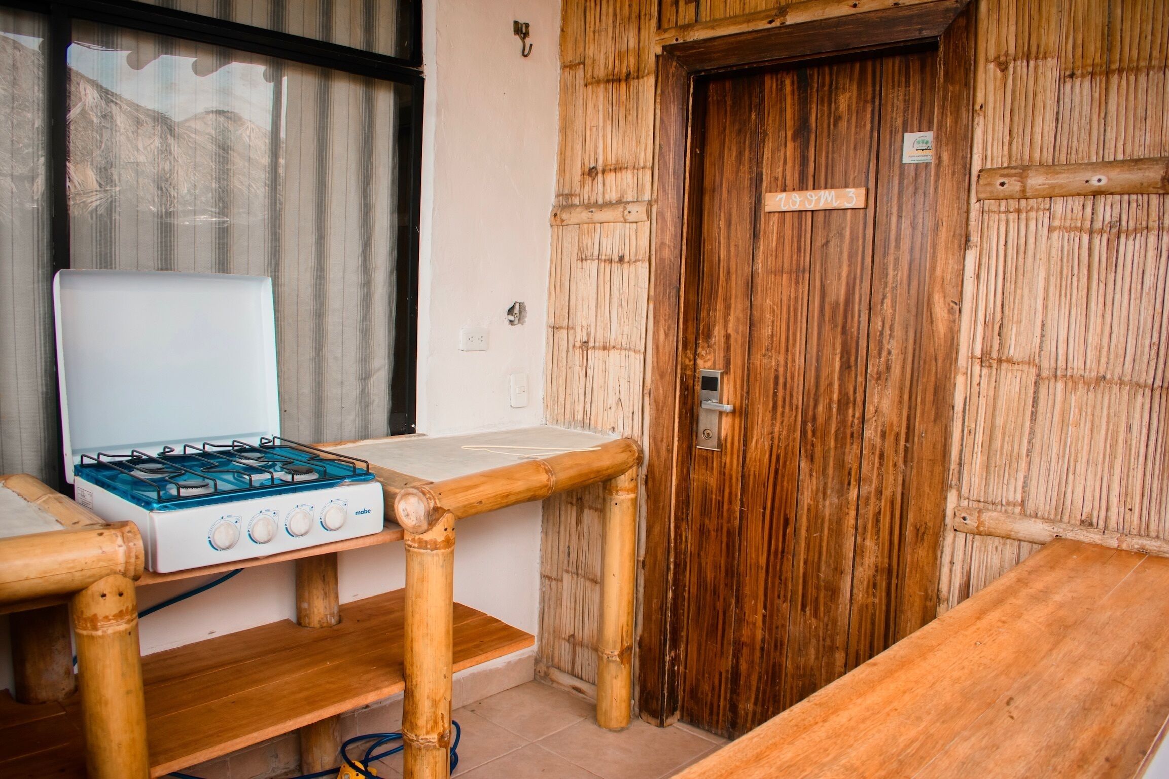 A room with a gas stove, a wooden table, and a door with a sign.