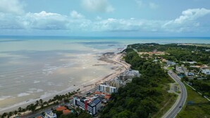 Vista aérea de una zona costera con playa, edificios y una carretera.
