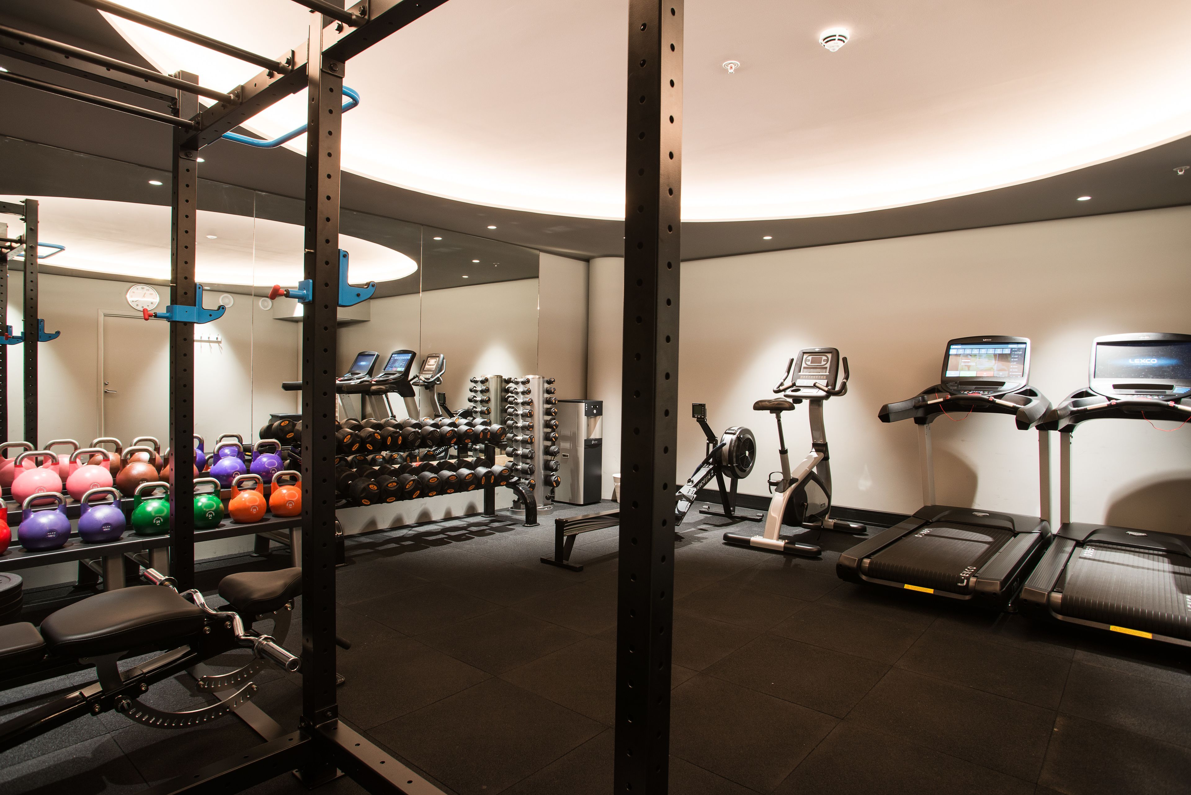 A gym with weightlifting equipment, treadmills, and cardio machines.