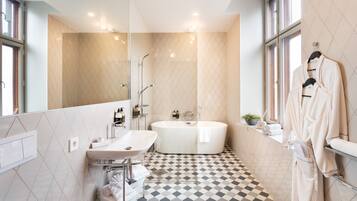 A modern bathroom with a freestanding bathtub, a vanity with a sink, and a large mirror.