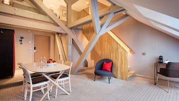A modern interior with a dining area, a staircase, and a seating area.