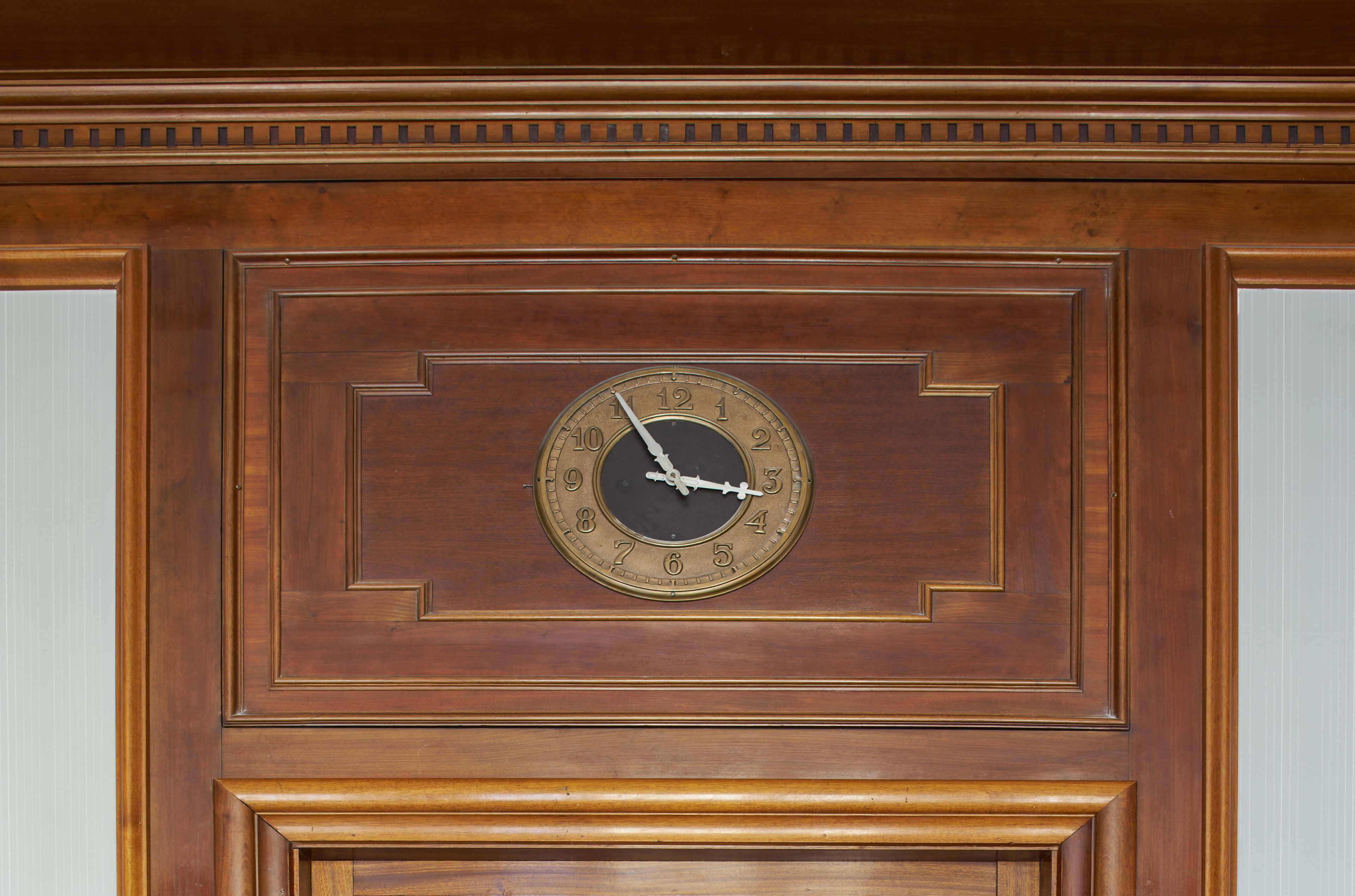 Un reloj de pared con marco de madera y esfera redonda.