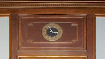 A wall-mounted clock with a wooden frame and a circular face.
