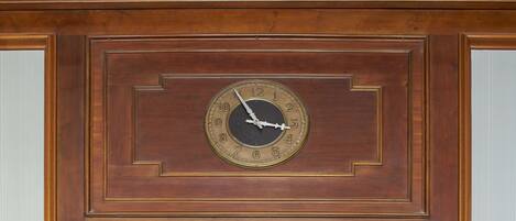 Un reloj de pared con marco de madera y esfera redonda.