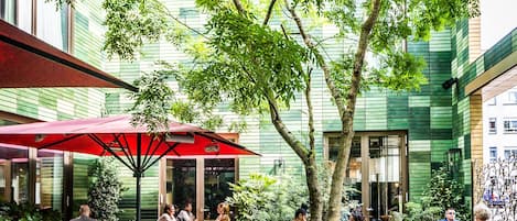 An outdoor seating area with tables, chairs, and umbrellas.