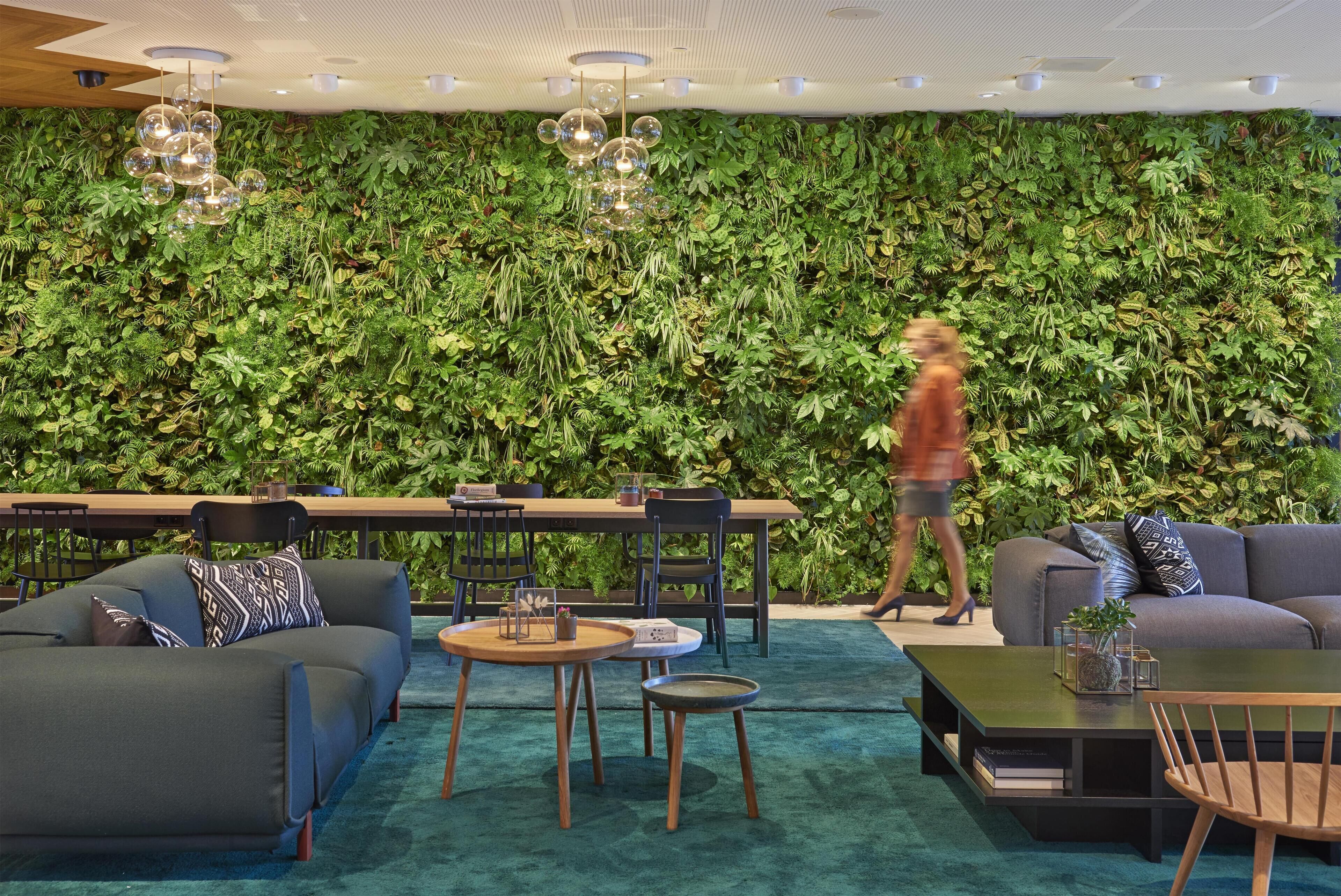 A modern interior with a green wall, a dining area, and seating arrangements.