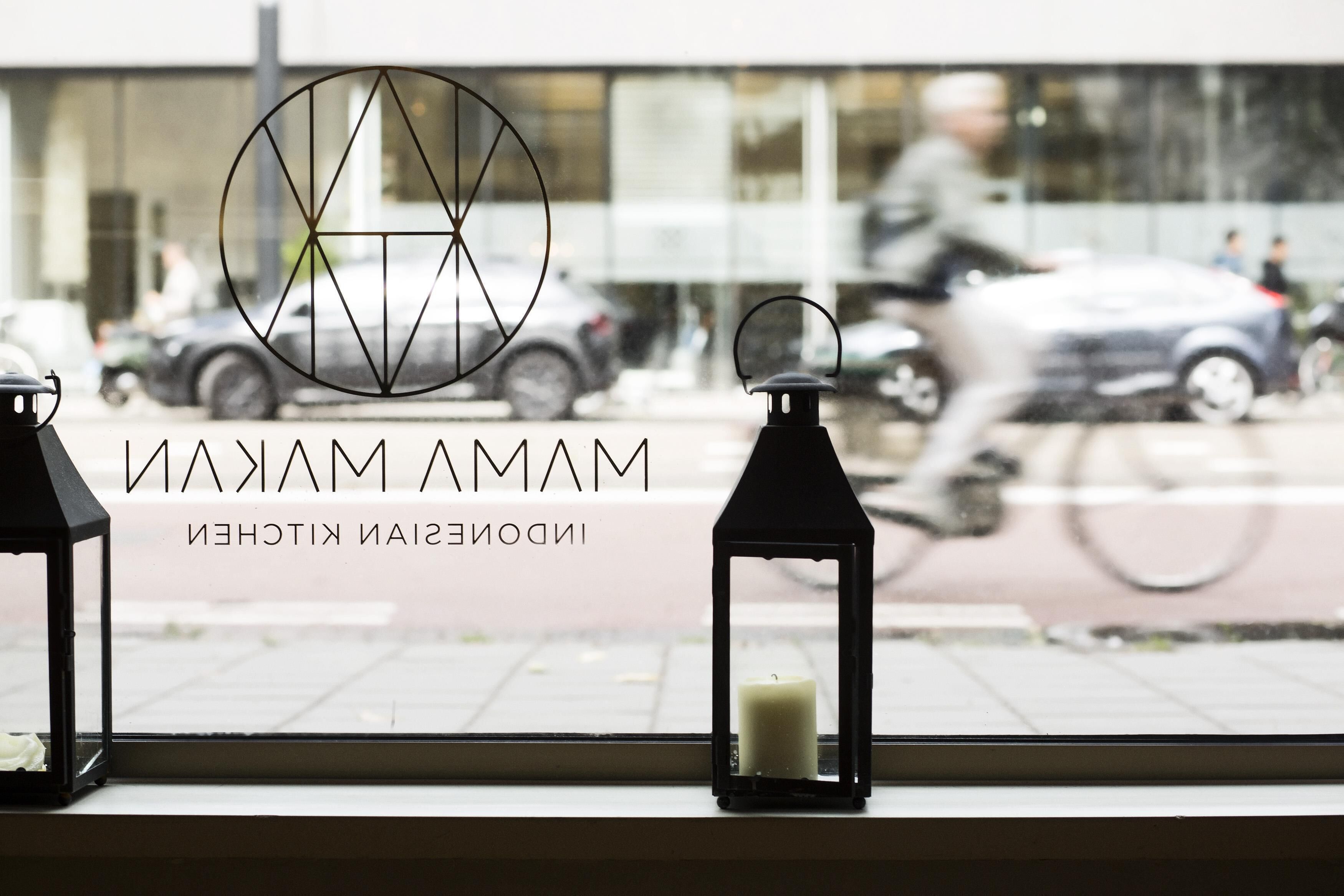 Blick aus dem Fenster mit einem Logo und dem Text 'MAMAM' und 'INDOOR KITCHEN'.