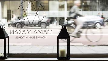 Blick aus dem Fenster mit einem Logo und dem Text 'MAMAM' und 'INDOOR KITCHEN'.