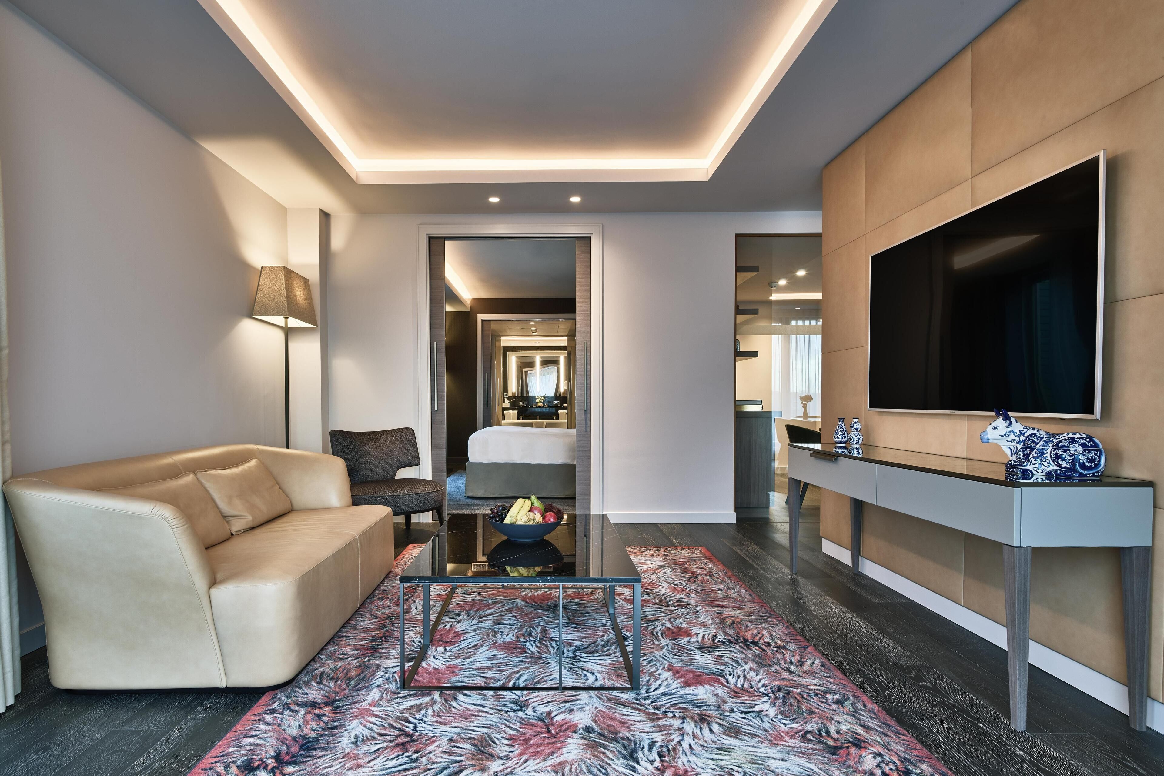 A modern living room with a sofa, a coffee table, a TV, and a console table with decorative items.