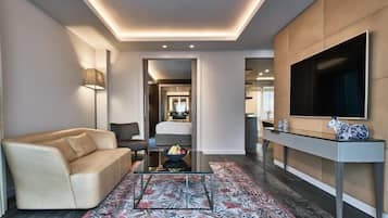Una sala de estar moderna con un sofá, una mesa de centro, un televisor y un mueble consola con adornos.