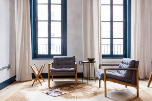 Loft de diseñador, 1 cama Queen size, cocina, vista a la ciudad | Área de sala de estar | Televisión de pantalla plana, iPad, Netflix y películas con cargo 