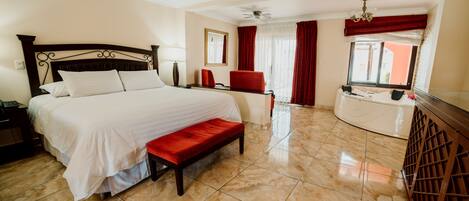 Habitación de hotel con una cama grande, un banco, un escritorio y una ventana con cortinas.