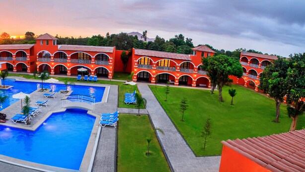 A resort with multiple swimming pools, a central water feature, and a large outdoor area with lounge chairs. - HACIENDA SAN JUAN RESORT   (San Juan Bautista)