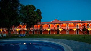 A hotel with a swimming pool, multiple balconies, and a central courtyard. - HACIENDA SAN JUAN RESORT   (San Juan Bautista)