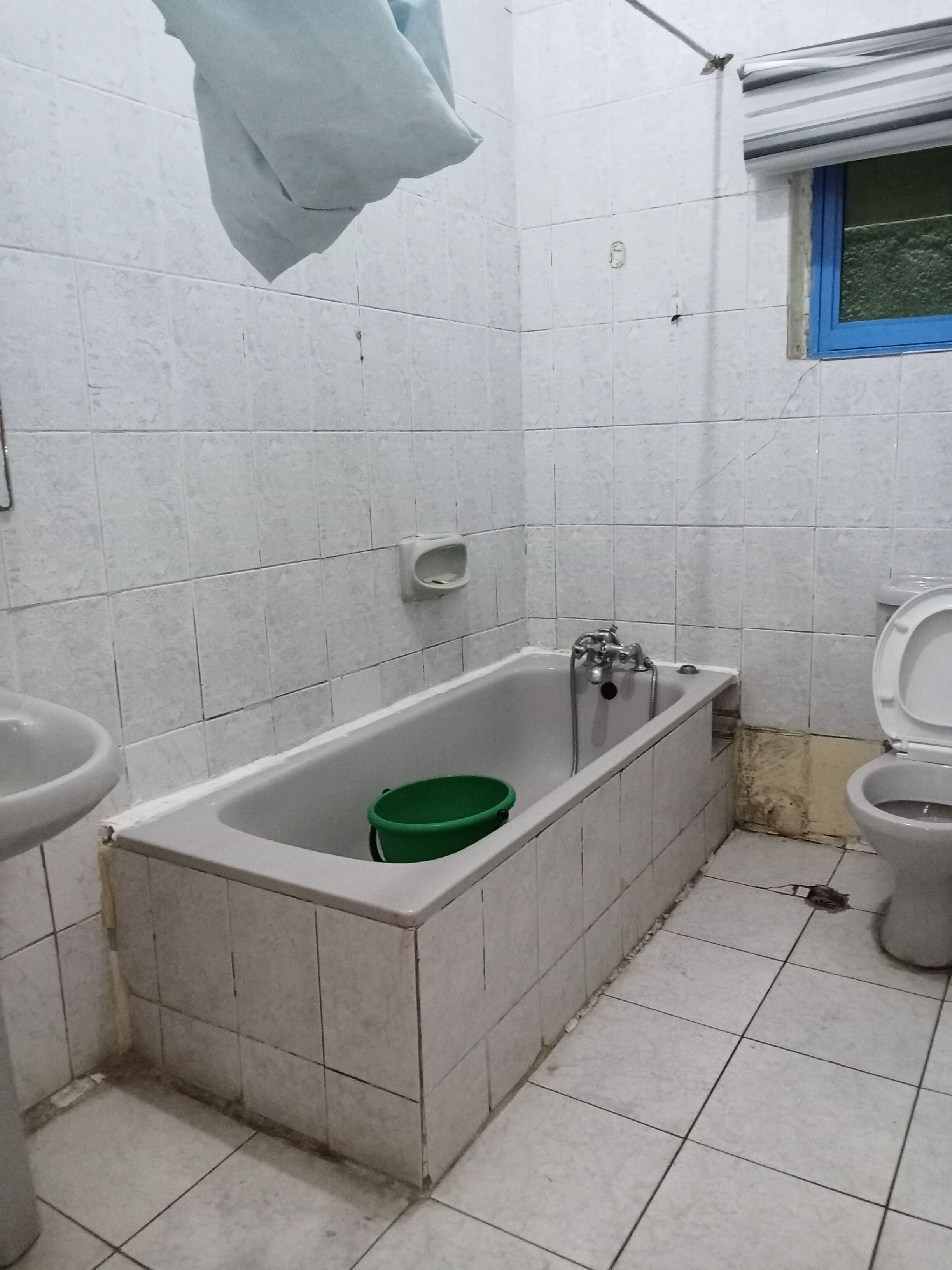 A small, tiled bathroom with a bathtub, a toilet, and a sink.