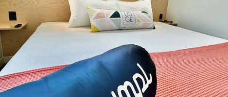 A hotel room with a bed, a window, and a nightstand.