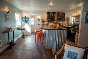 Ein gemütliches Café mit einer Holztresore, roten Barhocker und einer Kreidetafel-Speisekarte.