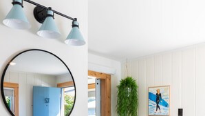 A modern bathroom with a sink, mirror, and three pendant lights. - Gravity Haus Westport (Westport)