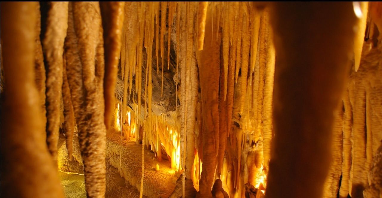 Interior de cueva con estalactitas y estalagmitas.