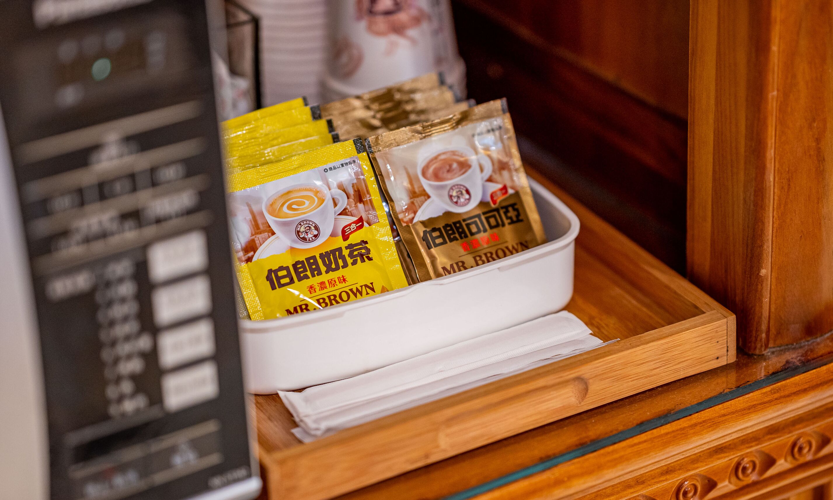 A tray with coffee packets and a cup of coffee.