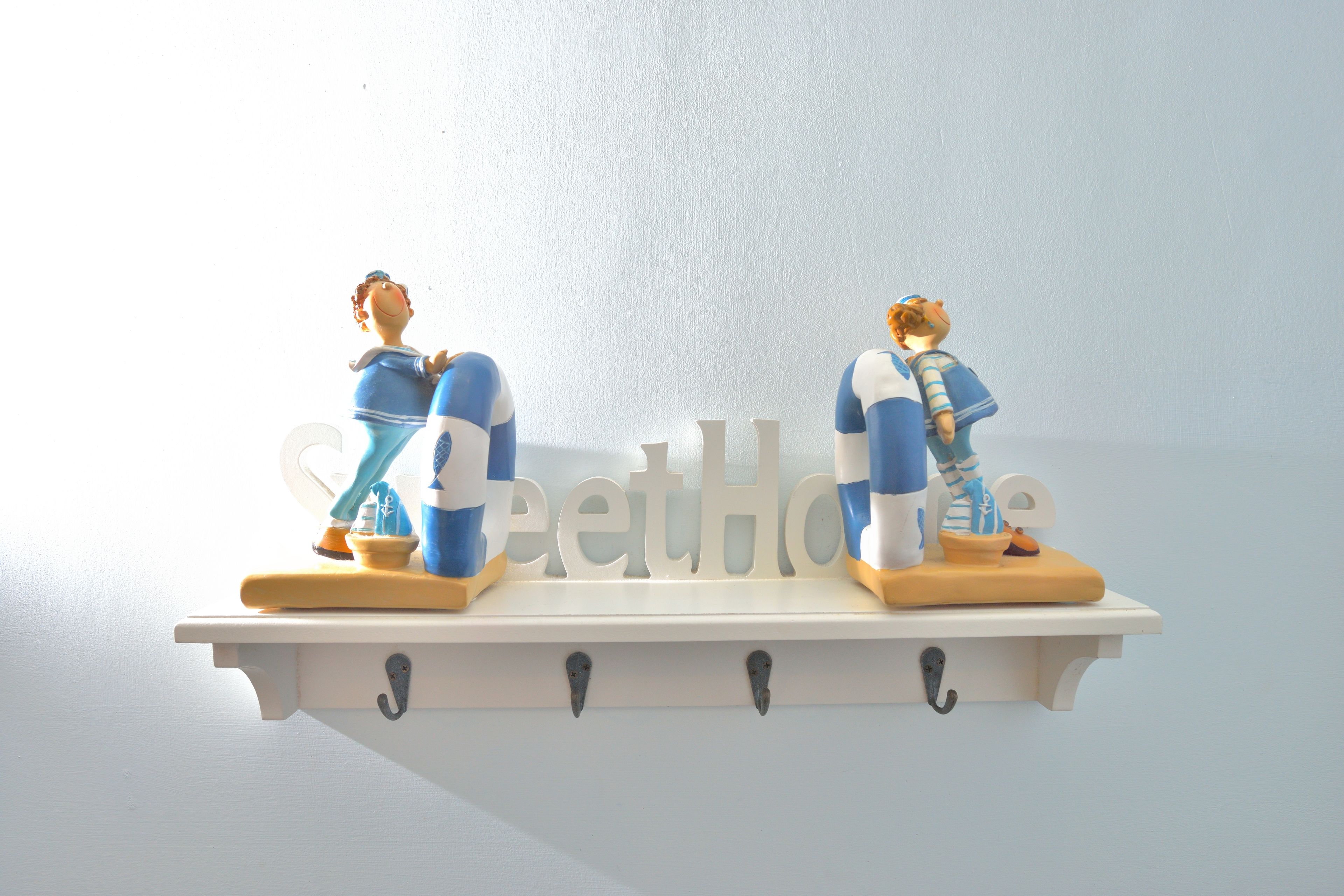 Two figurines on a shelf with a nameplate.