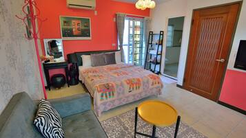A bedroom with a bed, a sofa, a chair, a desk, and a wardrobe.