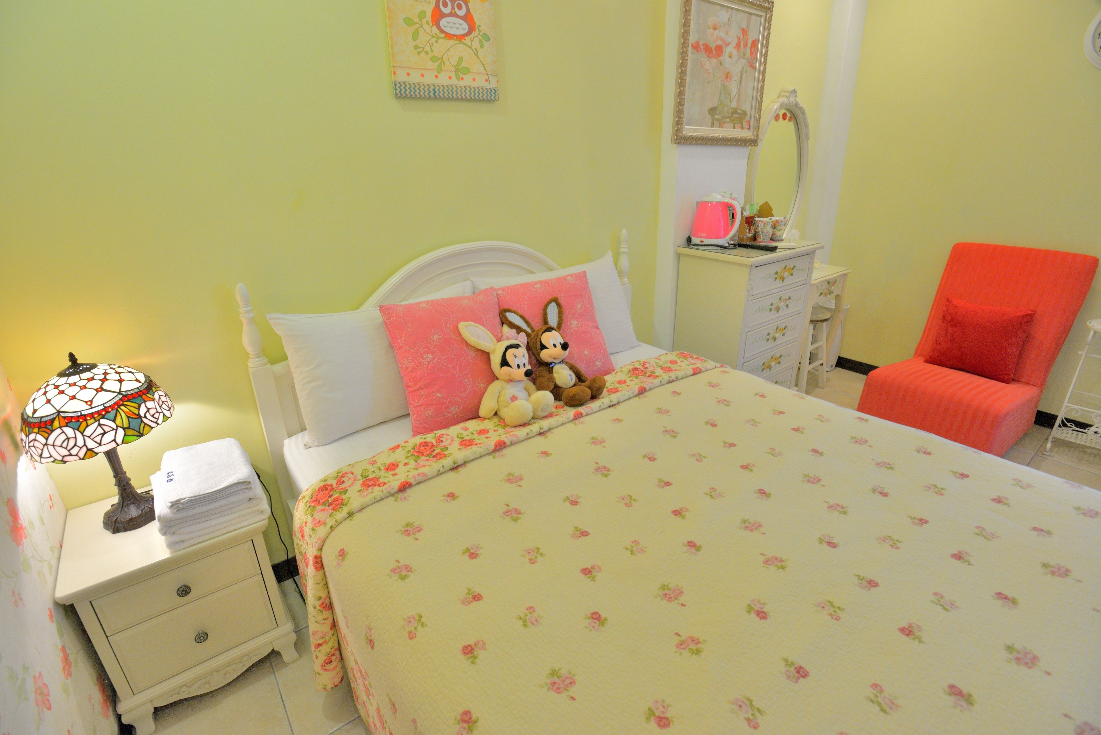 Un dormitorio con una cama, una mesita de noche, una silla y un aparador.