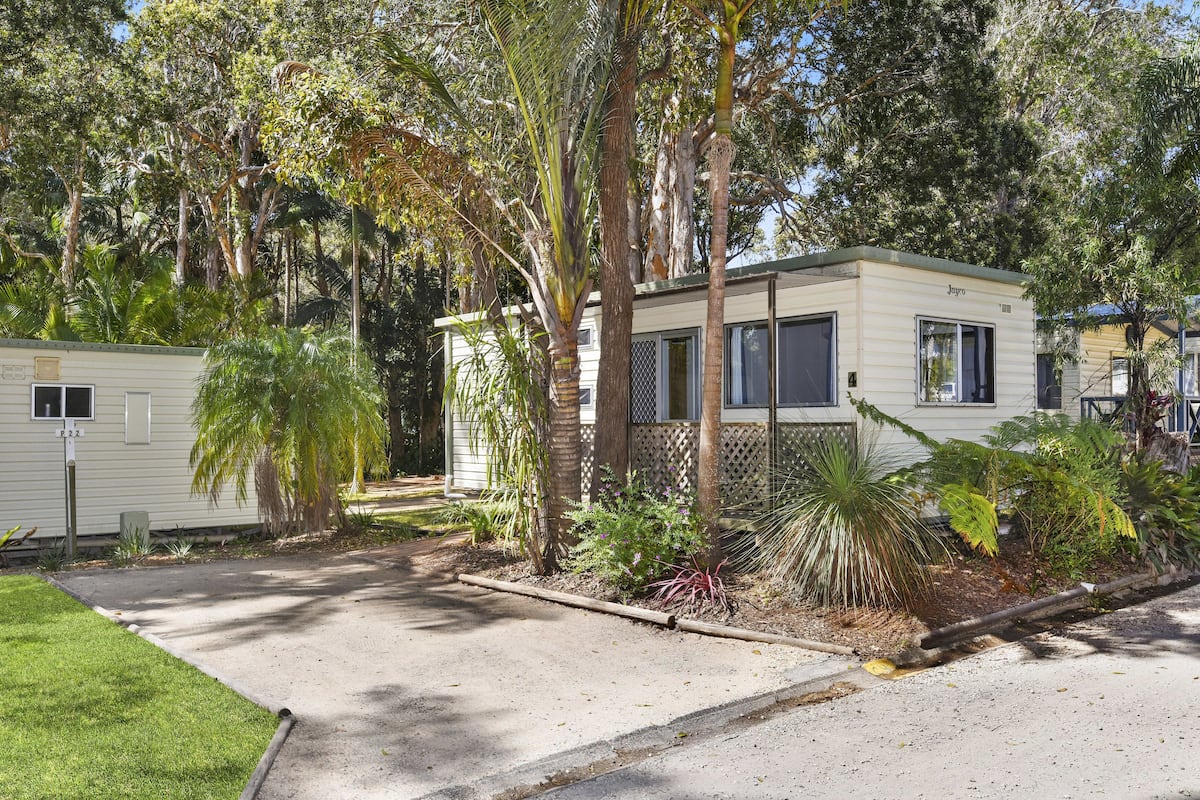 A mobile home with a fenced yard and a small garden area.