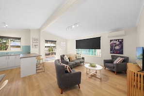 A modern living space with a kitchen, dining area, and seating area.