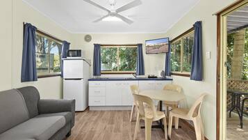 Cocina compacta con comedor, ventilador de techo y vistas al exterior.