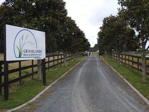 A sign for Grasslands Bed & Breakfast with a gravel path leading to a building. - Grasslands Bed & Breakfast (Cambridge)