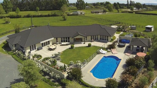 A large house with a swimming pool, surrounded by a well-maintained lawn and a fenced yard. - Grasslands Bed & Breakfast (Cambridge)
