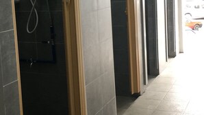 Un pasillo con paredes de azulejos y puertas, un secador de manos y un letrero que dice 'KEL'.