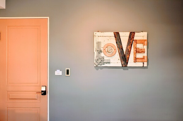 A room with a closed door, a wall-mounted artwork, and a light switch. - CheeseBon (Hualien City)