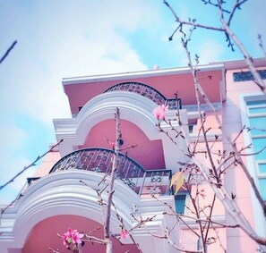A multi-story building with balconies and a pink facade. - CheeseBon (Hualien City)