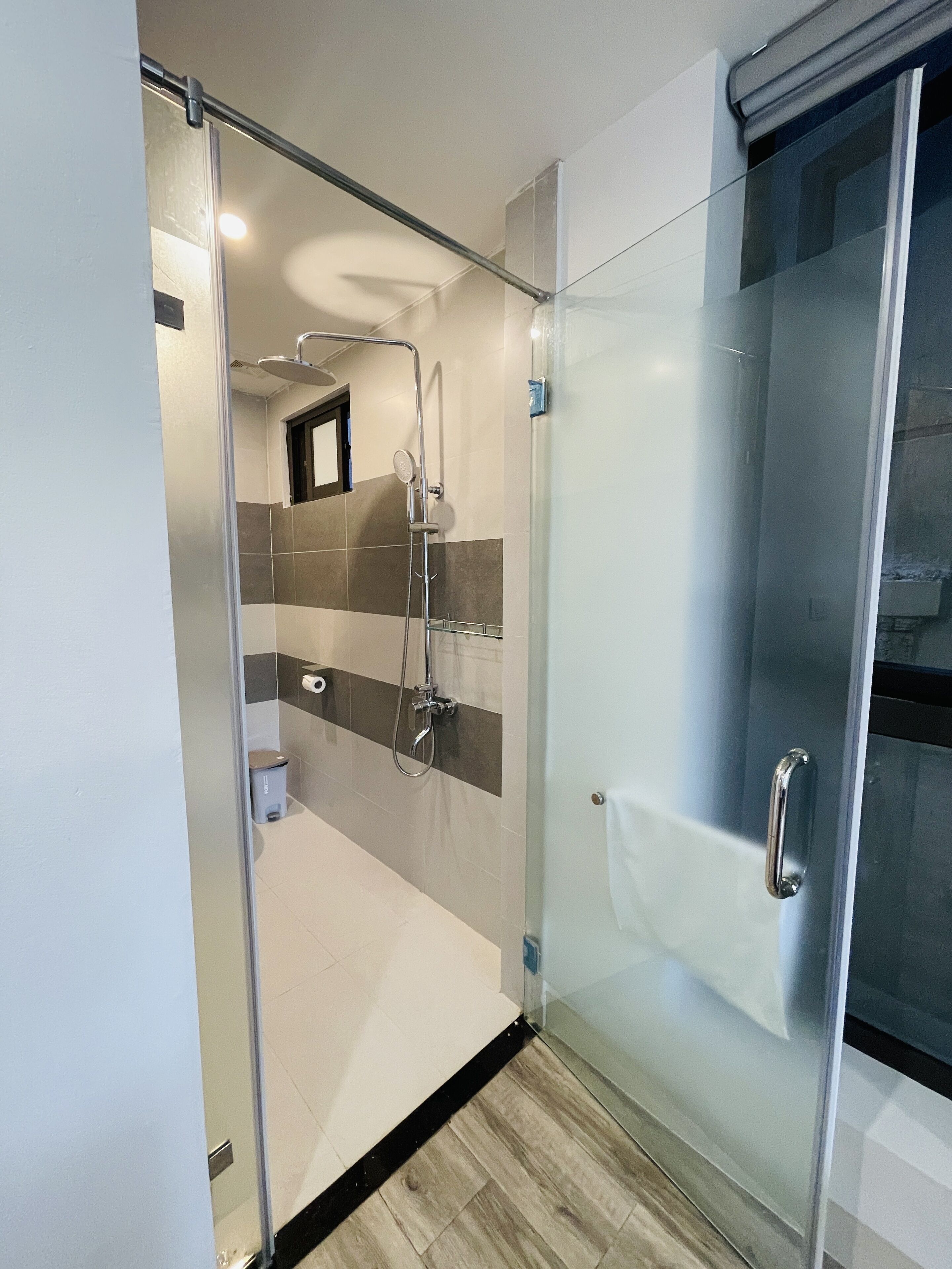 Un baño moderno con cabina de ducha de vidrio, inodoro y lavamanos.