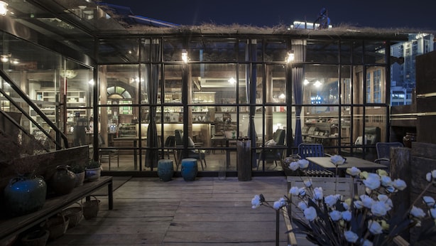 A glass-enclosed patio area with seating and potted plants. - Zhangjiajie Wang Yi Inn (Zhangjiajie)