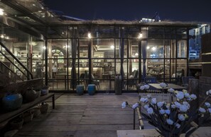A glass-enclosed patio area with seating and potted plants. - Zhangjiajie Wang Yi Inn (Zhangjiajie)