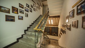 A staircase with a wooden handrail and black balusters, flanked by walls adorned with framed pictures. - Zhangjiajie Wang Yi Inn (Zhangjiajie)
