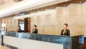 A reception desk with marble countertops and a modern chandelier. - Landison Plaza Hotel Ningbo (Ningbo)