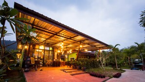A modern house with a covered patio, outdoor seating, and a garden. - Sirilanta Resort (Ko Lanta)