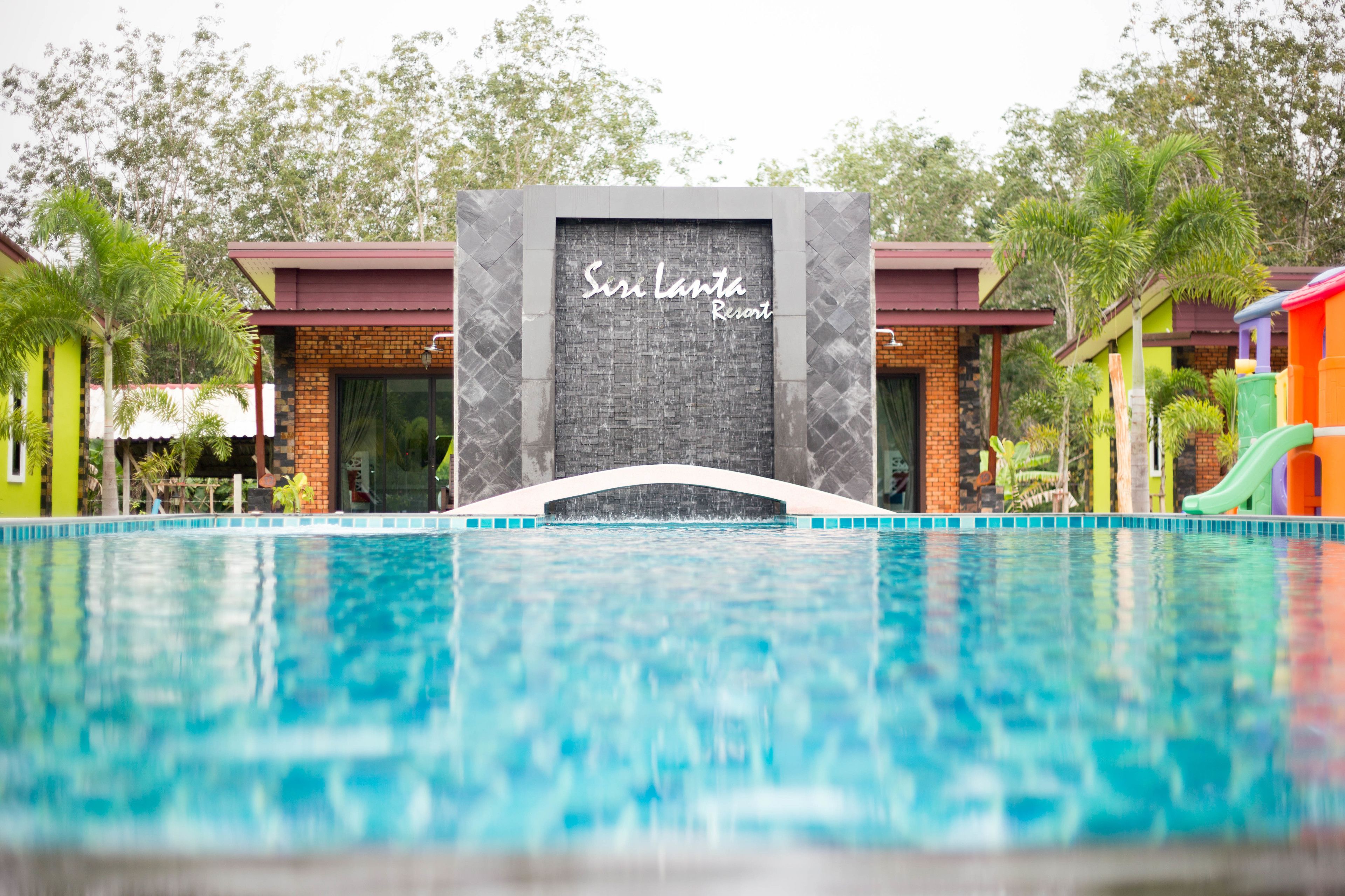 Uma piscina com uma placa indicando "Susi Lanta Resort" ao fundo.