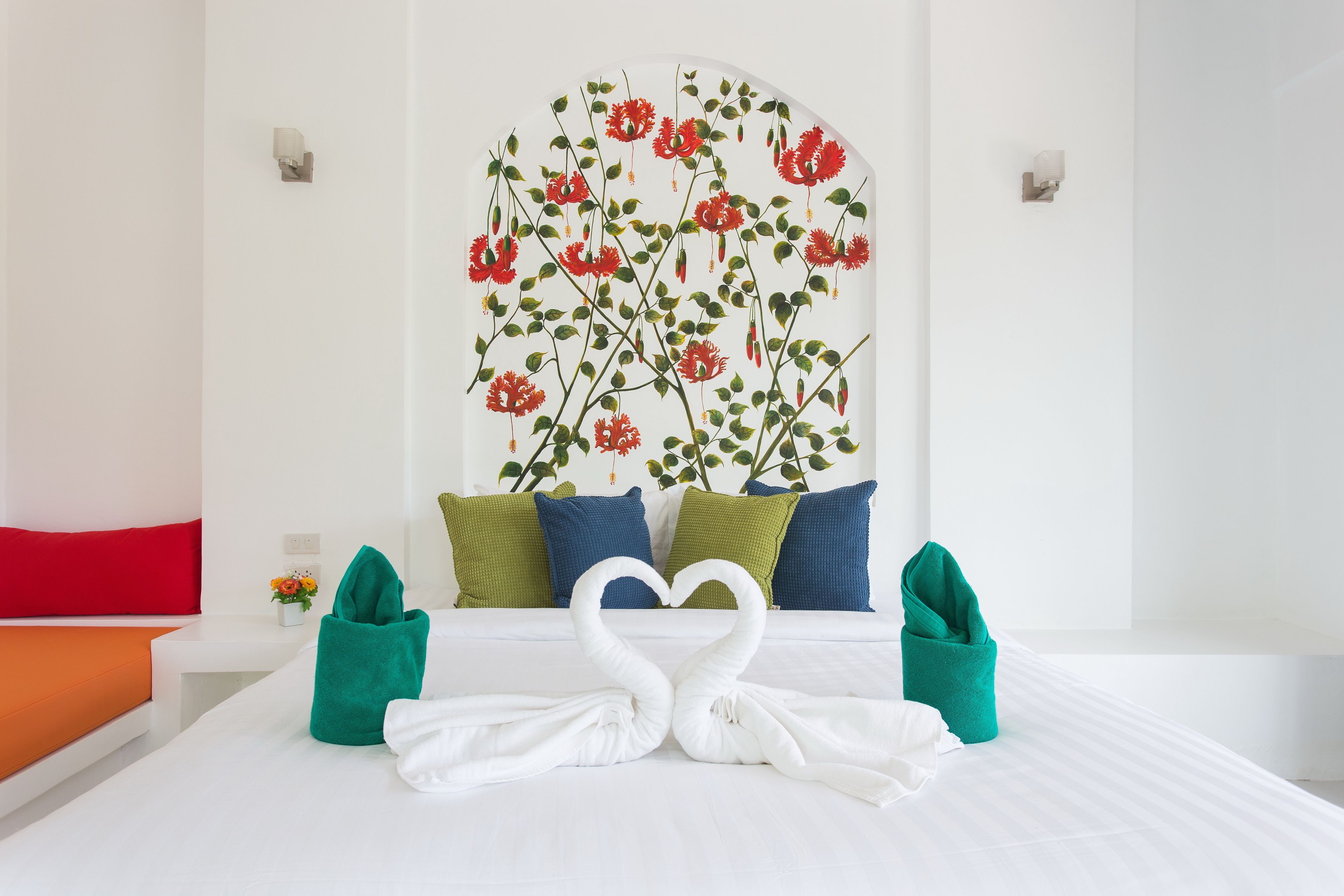 A hotel room with a bed, pillows, and towels arranged in a heart shape.