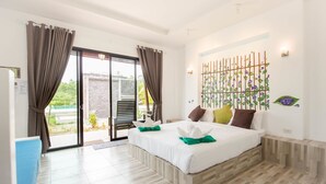 A hotel room with a bed, a desk, a chair, and a view of the outdoors. - Sirilanta Resort (Ko Lanta)